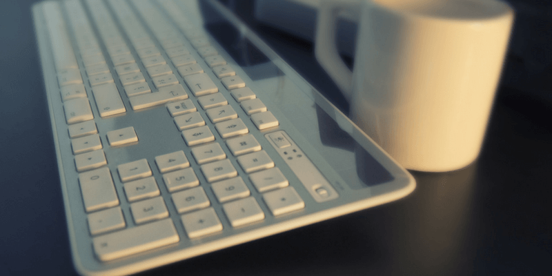 Computer keyboard and coffee mug