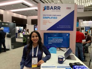 Swathi West, HITRUST manager, stands near BARR's exhibit.